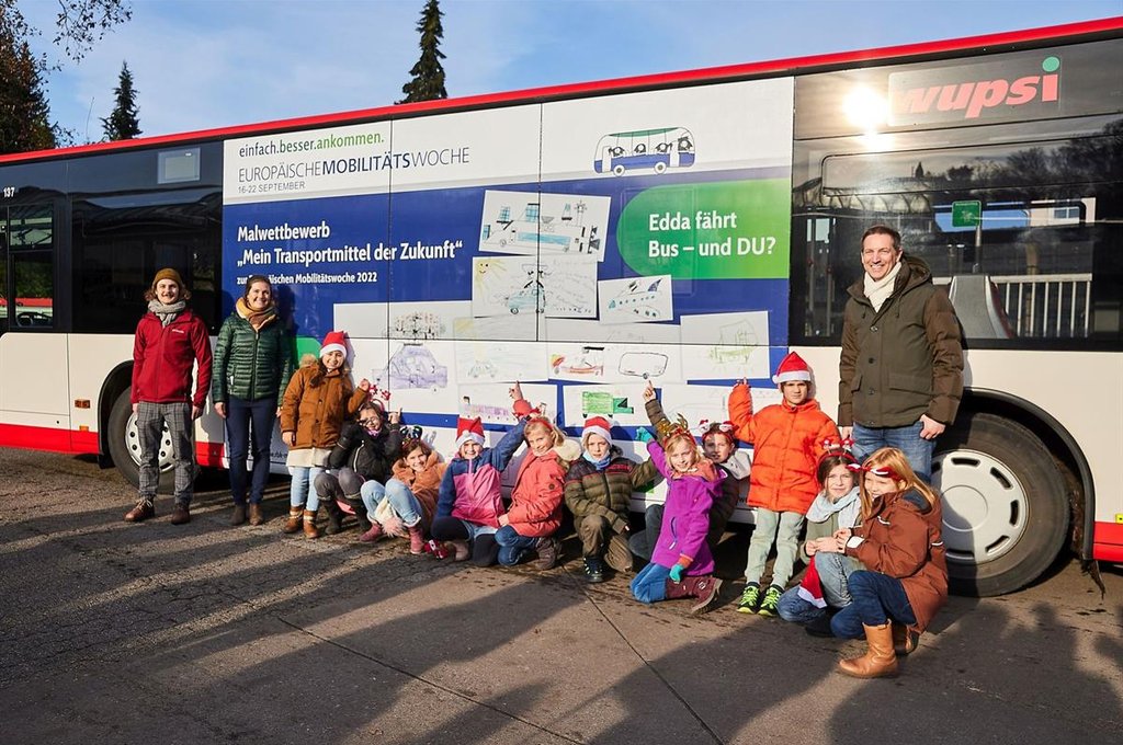 Schüllerinnen und Schüler der Concordiaschule in Schildgen vor dem Bus, der ihre Bilder der Mobilität der Zukunft zeigt