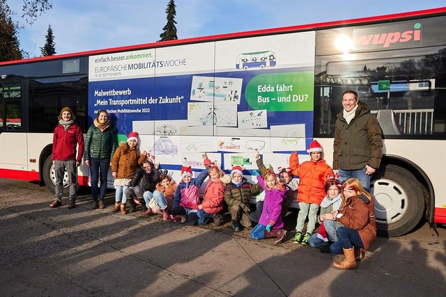 Schüllerinnen und Schüler der Concordiaschule in Schildgen vor dem Bus, der ihre Bilder der Mobilität der Zukunft zeigt