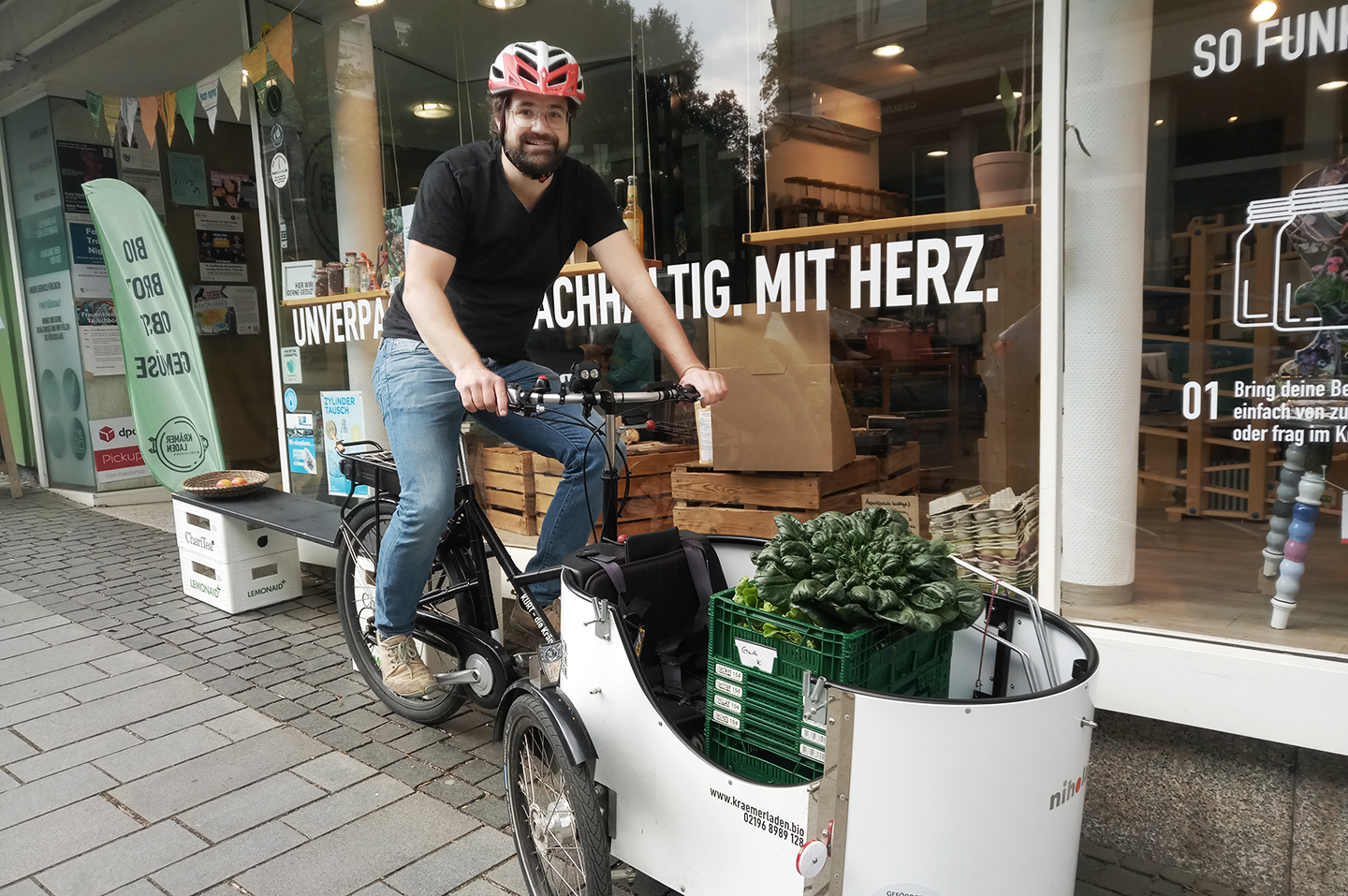 Jochen Krämer auf einem Lastenrad vor seinem Krämerladen